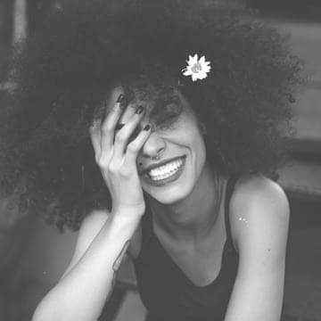 Woman sitting and smilling with hand on her face